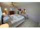Bright bedroom with tiled floors, ceiling fan, floral bedding, and a view into the ensuite bathroom at 9186 Patio Ct, Spring Hill, FL 34608