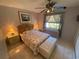 Comfortable bedroom with natural light, ceiling fan, tile flooring and a storage ottoman at 9186 Patio Ct, Spring Hill, FL 34608