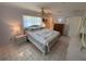 Serene bedroom with tiled floors, ceiling fan, floral bedding, and ample natural light from the windows at 9186 Patio Ct, Spring Hill, FL 34608