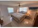 Comfortable bedroom features a ceiling fan, two windows, a floral quilt, and coordinating lamps at 9186 Patio Ct, Spring Hill, FL 34608