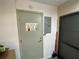 Attractive entry door with decorative glass window pane and modern hardware and light gray color at 9186 Patio Ct, Spring Hill, FL 34608