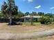 Inviting home featuring a lush lawn, mature palm trees, and charming curb appeal at 9186 Patio Ct, Spring Hill, FL 34608