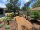 Beautiful garden featuring a winding stone path, mature trees, and vibrant flowers, enhancing the outdoor experience at 9186 Patio Ct, Spring Hill, FL 34608