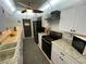 Galley kitchen features updated white cabinetry, granite countertops, subway tile backsplash, and black appliances at 9186 Patio Ct, Spring Hill, FL 34608