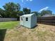 Exterior shed with ramp access, providing storage for equipment and supplies in grassy backyard at 9186 Patio Ct, Spring Hill, FL 34608