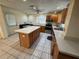 Spacious kitchen featuring a large island, tile flooring, and plenty of cabinet space at 9285 Carthage Rd, Spring Hill, FL 34608