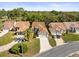 An aerial view showing the house with a tile roof, landscaping, driveway, and neighboring homes at 9355 French Quarters Cir, Weeki Wachee, FL 34613
