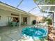 A backyard featuring a screened-in patio with a hot tub and wicker dining set at 9355 French Quarters Cir, Weeki Wachee, FL 34613