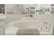 Large soaking tub with tiled surround, perfect for relaxation, in this bright bathroom at 9355 French Quarters Cir, Weeki Wachee, FL 34613