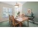 Bright dining area with large windows, a wooden table set for a meal, and stylish decorations at 9355 French Quarters Cir, Weeki Wachee, FL 34613