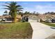 Charming single-story home with a well-manicured lawn, mature palm tree, and a two-car garage at 9355 French Quarters Cir, Weeki Wachee, FL 34613