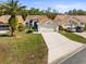 Charming single-story home with a well-manicured lawn, mature palm tree, and a two-car garage at 9355 French Quarters Cir, Weeki Wachee, FL 34613