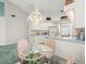 Eat-in kitchen features white cabinets, an island sink and an adjacent table with seating for four at 9355 French Quarters Cir, Weeki Wachee, FL 34613