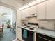 Bright kitchen featuring white cabinets, modern appliances, and light blue countertops with an adjacent breakfast area at 9355 French Quarters Cir, Weeki Wachee, FL 34613