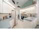 Bright kitchen featuring white cabinets, modern appliances, and light blue countertops with tiled backsplash at 9355 French Quarters Cir, Weeki Wachee, FL 34613