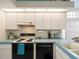 Bright kitchen features white cabinets, modern appliances, and light blue countertops with tile backsplash at 9355 French Quarters Cir, Weeki Wachee, FL 34613