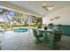 A screened in patio featuring a hot tub, and dining area with wicker chairs at 9355 French Quarters Cir, Weeki Wachee, FL 34613