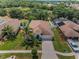 Aerial view of a single-Gathering home with a well-manicured lawn and lush tropical landscaping at 10106 Tolman Dr, Hudson, FL 34667