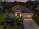 Dusk aerial view of home featuring a lush landscaped yard, arched entryway and two car garage at 10106 Tolman Dr, Hudson, FL 34667