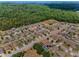 An aerial view showcases homes in a residential community surrounded by lush greenery and a lake at 10106 Tolman Dr, Hudson, FL 34667