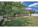Lush backyard with well-maintained lawn, mature trees, and a black chain link fence at 10106 Tolman Dr, Hudson, FL 34667