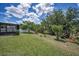 The backyard features lush green grass, a black fence and mature trees at 10106 Tolman Dr, Hudson, FL 34667