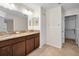 Bathroom featuring double sinks with granite counters, tile flooring, and access to a walk-in closet at 10106 Tolman Dr, Hudson, FL 34667