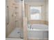 Bright bathroom featuring a separate shower and soaking tub, enhanced by natural light from the window at 10106 Tolman Dr, Hudson, FL 34667