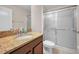 Bathroom features a vanity with granite countertop and a shower with sliding glass doors at 10106 Tolman Dr, Hudson, FL 34667