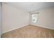 Cozy bedroom with plush carpet, neutral walls, and a window offering natural light at 10106 Tolman Dr, Hudson, FL 34667