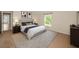 Comfortable bedroom with a soft rug, a large window, and a beautifully decorated queen-size bed at 10106 Tolman Dr, Hudson, FL 34667