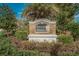 Stone sign at the entrance to the Briar Oaks community with lush landscaping at 10106 Tolman Dr, Hudson, FL 34667