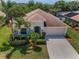 Charming single-story home with a well-manicured lawn, palm trees, and attached two-car garage at 10106 Tolman Dr, Hudson, FL 34667