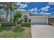 Inviting home exterior with a two-car garage, lush lawn, and beautiful landscaping at 10106 Tolman Dr, Hudson, FL 34667