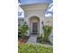 Inviting front entrance with arched portico, stylish door, and manicured landscaping at 10106 Tolman Dr, Hudson, FL 34667