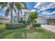 Charming home with a well-manicured lawn, mature palm trees, and an attached two-car garage at 10106 Tolman Dr, Hudson, FL 34667