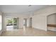 Spacious living area featuring tile floors, high ceilings, and access to the lanai through sliding glass doors at 10106 Tolman Dr, Hudson, FL 34667
