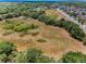 Expansive field surrounded by lush trees and neighborhood homes in a serene setting at 10106 Tolman Dr, Hudson, FL 34667
