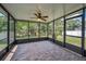 Enclosed patio with brick flooring, ceiling fan, and backyard views at 10106 Tolman Dr, Hudson, FL 34667