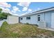 Side view of a light blue house with a utility shed, small landscaping bed, and small windows at 10235 Skyland St, Spring Hill, FL 34608