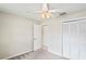 This is a carpeted bedroom with a ceiling fan and a closet with paneled doors at 10235 Skyland St, Spring Hill, FL 34608