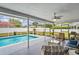 Covered and screened outdoor living area with pool, chairs, and other seating arrangements at 10235 Skyland St, Spring Hill, FL 34608