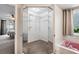Walk-in closet featuring wire shelving, mirrored doors, and adjacent pink bath tub at 10235 Skyland St, Spring Hill, FL 34608