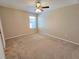 A spacious bedroom with neutral walls and carpet, a ceiling fan, and a window providing natural light at 10238 Perthshire Cir, Land O Lakes, FL 34638
