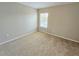 A spacious bedroom with neutral walls and carpet, and a window providing natural light at 10238 Perthshire Cir, Land O Lakes, FL 34638