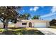 Charming single-story home featuring a well-maintained lawn, a two-car garage, and a lovely magnolia tree at 10478 Laval St, Spring Hill, FL 34608