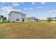 Large backyard with green and brown grass, and view of the rear of the house at 10823 Penny Gale Loop, San Antonio, FL 33576