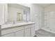 Bathroom featuring double sinks, sleek cabinets, and a walk-in shower at 10823 Penny Gale Loop, San Antonio, FL 33576