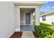 Inviting front porch with a gray door and well-maintained landscaping at 10823 Penny Gale Loop, San Antonio, FL 33576