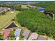 Aerial view of homes near a golf course and pond, surrounded by mature trees and lush landscaping in a lovely community at 1119 Dustan Pl, Trinity, FL 34655